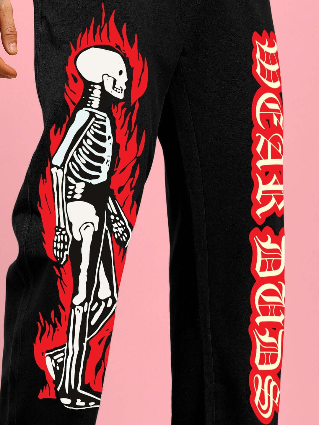 FLAMING SKELETON PRINTED RELAXED FIT JOGGER BLACK with bold flaming skeleton design and Gothic text on side, showcasing edgy streetwear style.