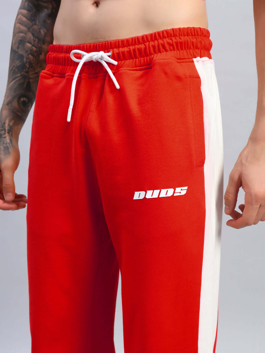 Man wearing red-white FLASH RELAXED FIT JOGGERS by DUDS, showcasing custom fit option. Comfortable, stylish athletic leisurewear.