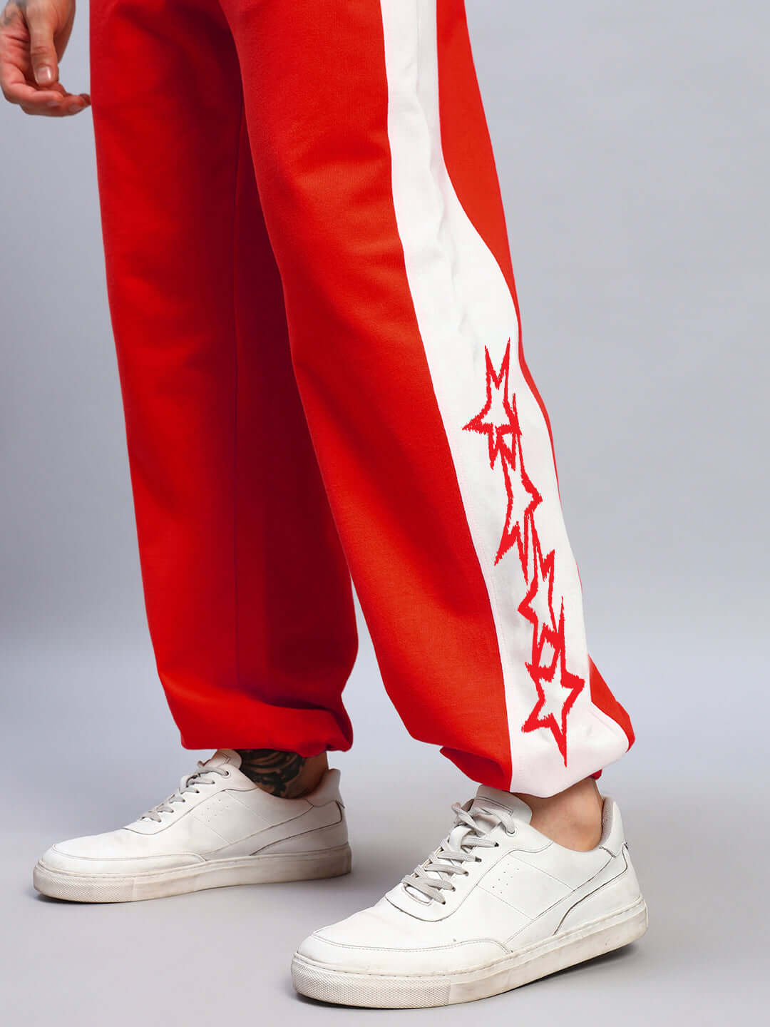 Red-white flash relaxed fit joggers with star embroidery, customizable, made to order by DUDS, shown with white sneakers.