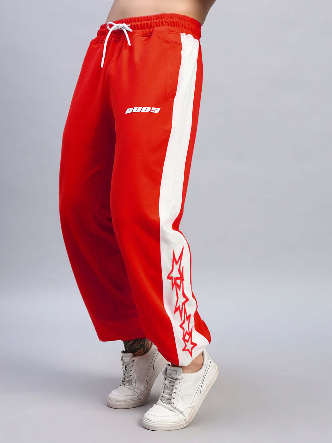 Flash relaxed fit joggers in red-white with side stripes, available for custom fit by DUDS, worn with white sneakers.