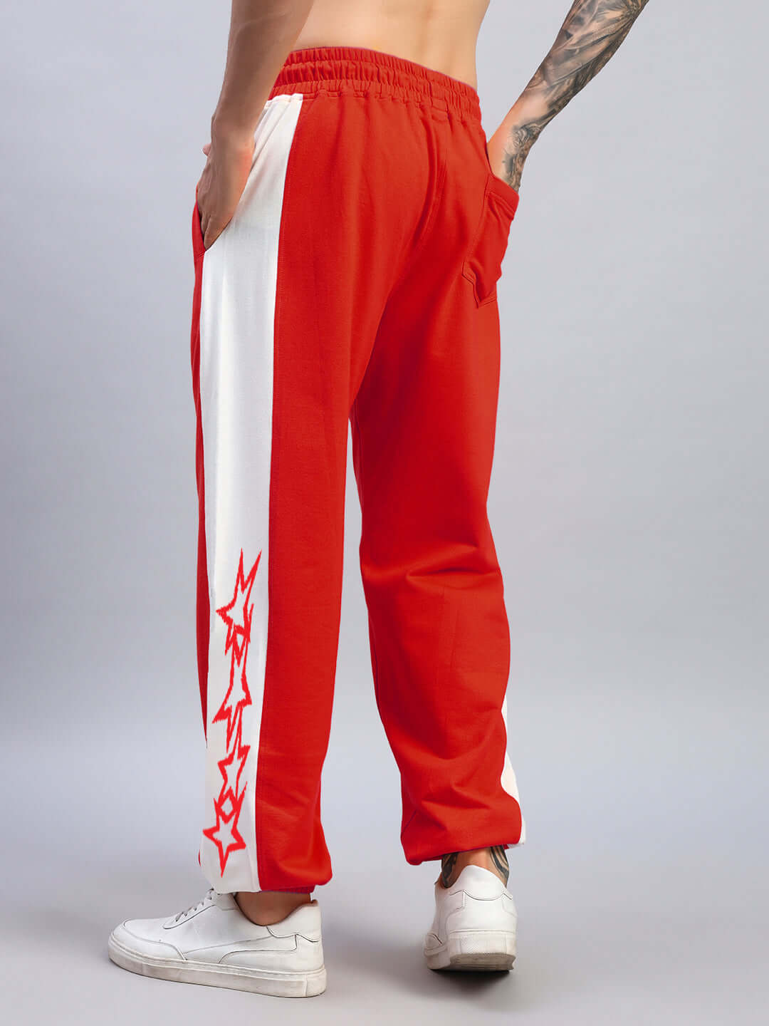 Model wearing FLASH RELAXED FIT JOGGERS in red and white, featuring side pockets and artistic design, made by DUDS tailors.