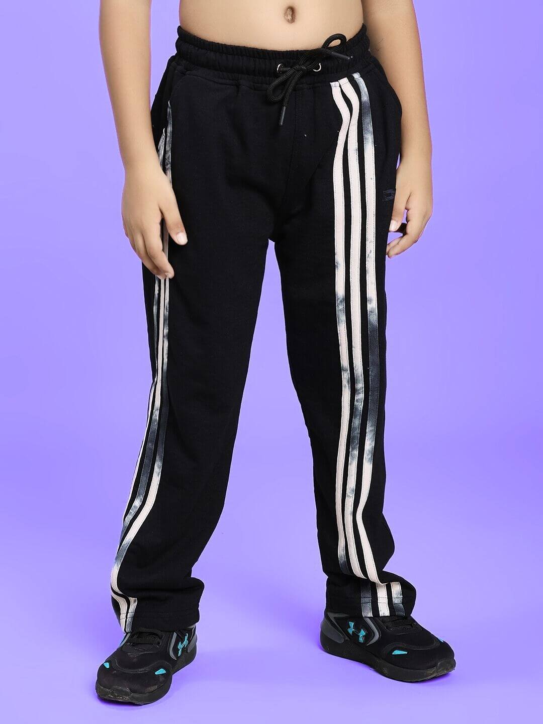 Child wearing FLICKER DESIGNER CO-ORD SET FOR BOYS GIRLS BLACK with striped pants and sneakers on purple background