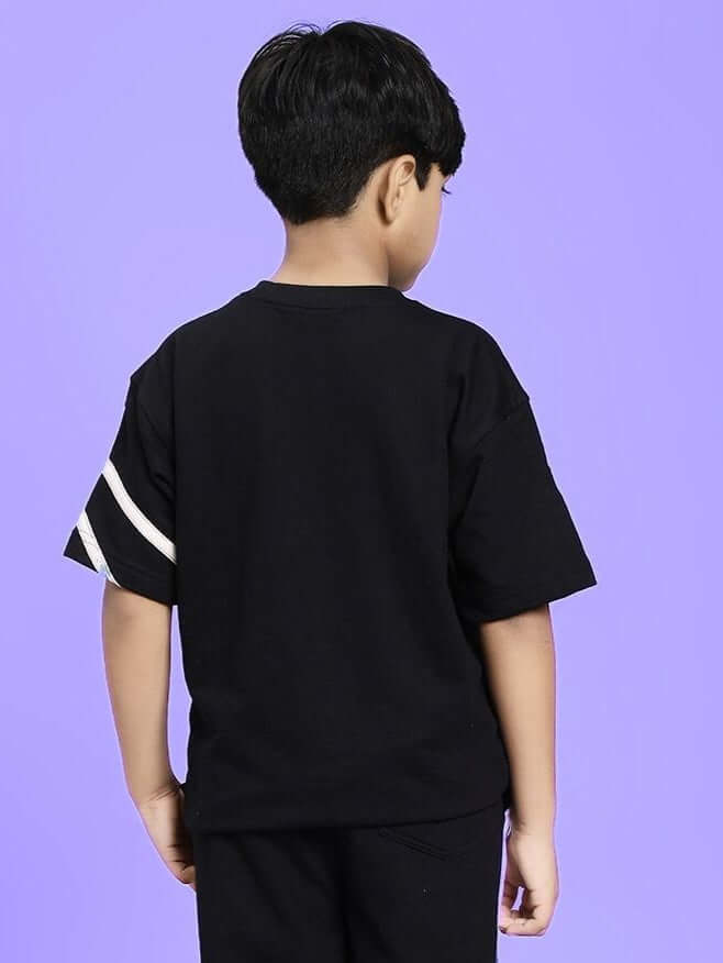 Back view of boy wearing FLICKER DESIGNER OVERSIZED T-SHIRT FOR BOYS AND GIRLS BLACK on purple background.