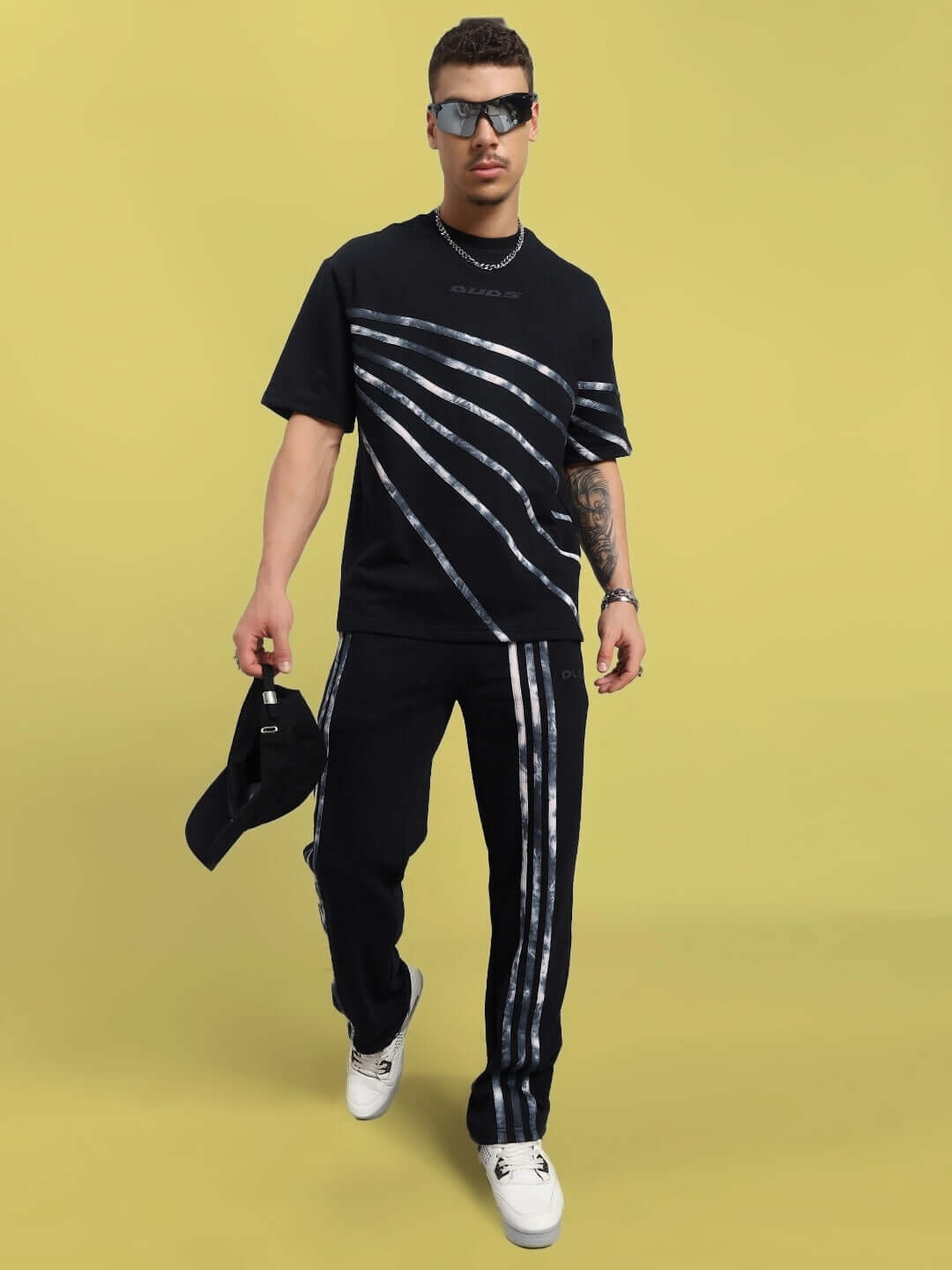 Man wearing Flicker Oversized Co-Ord Set in black, featuring unisex relaxed fit joggers and elasticated waistband for adjustable comfort.