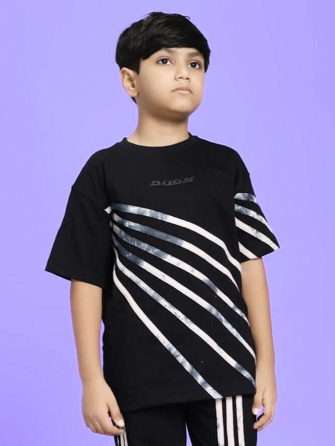 A young boy wearing a Flicker Designer Oversized T-Shirt for Boys and Girls Black with diagonal white and black stripes.