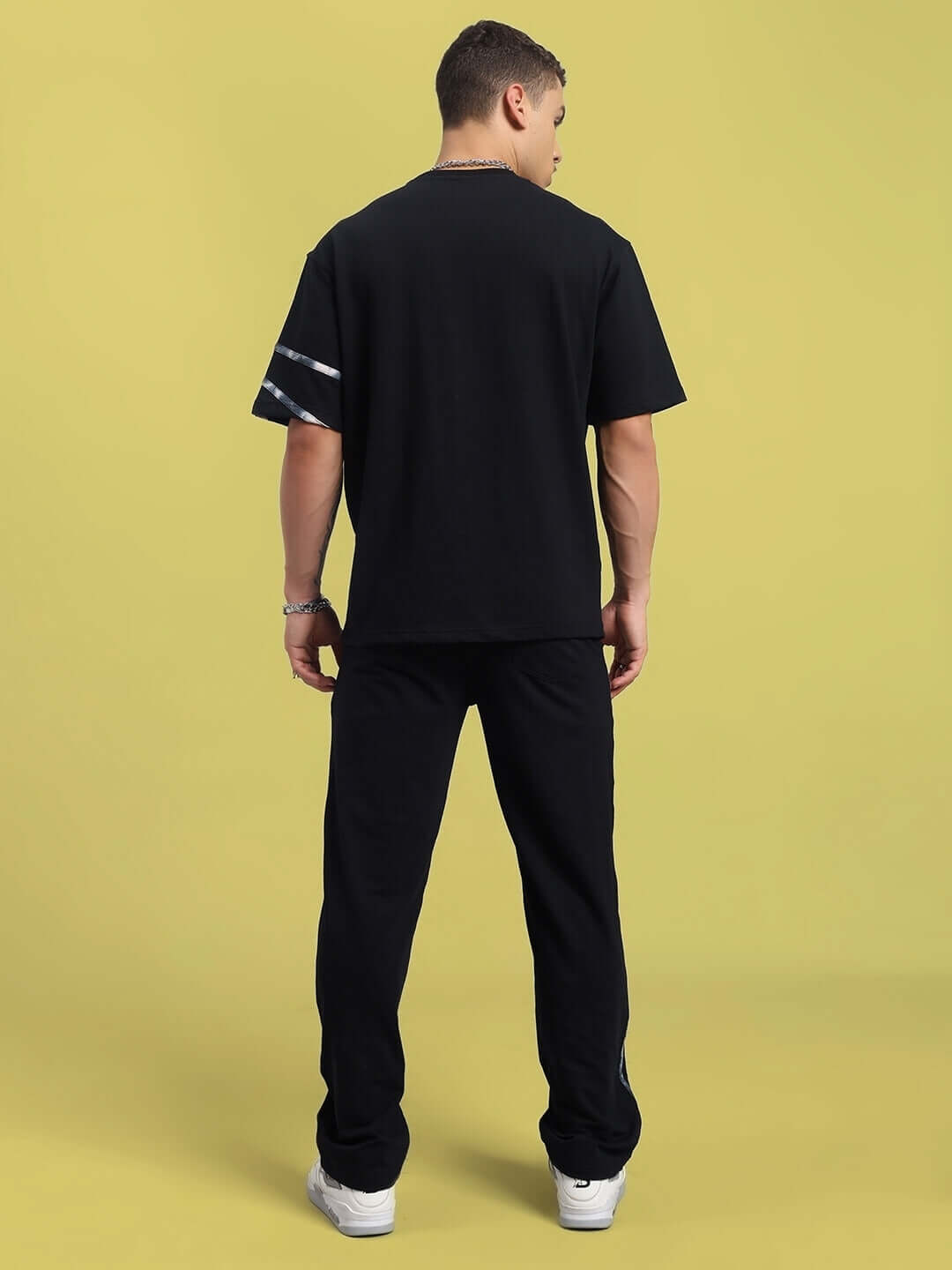 Unisex black oversized co-ord set with relaxed fit joggers and elasticated waistband, made of premium cotton blend, back view.