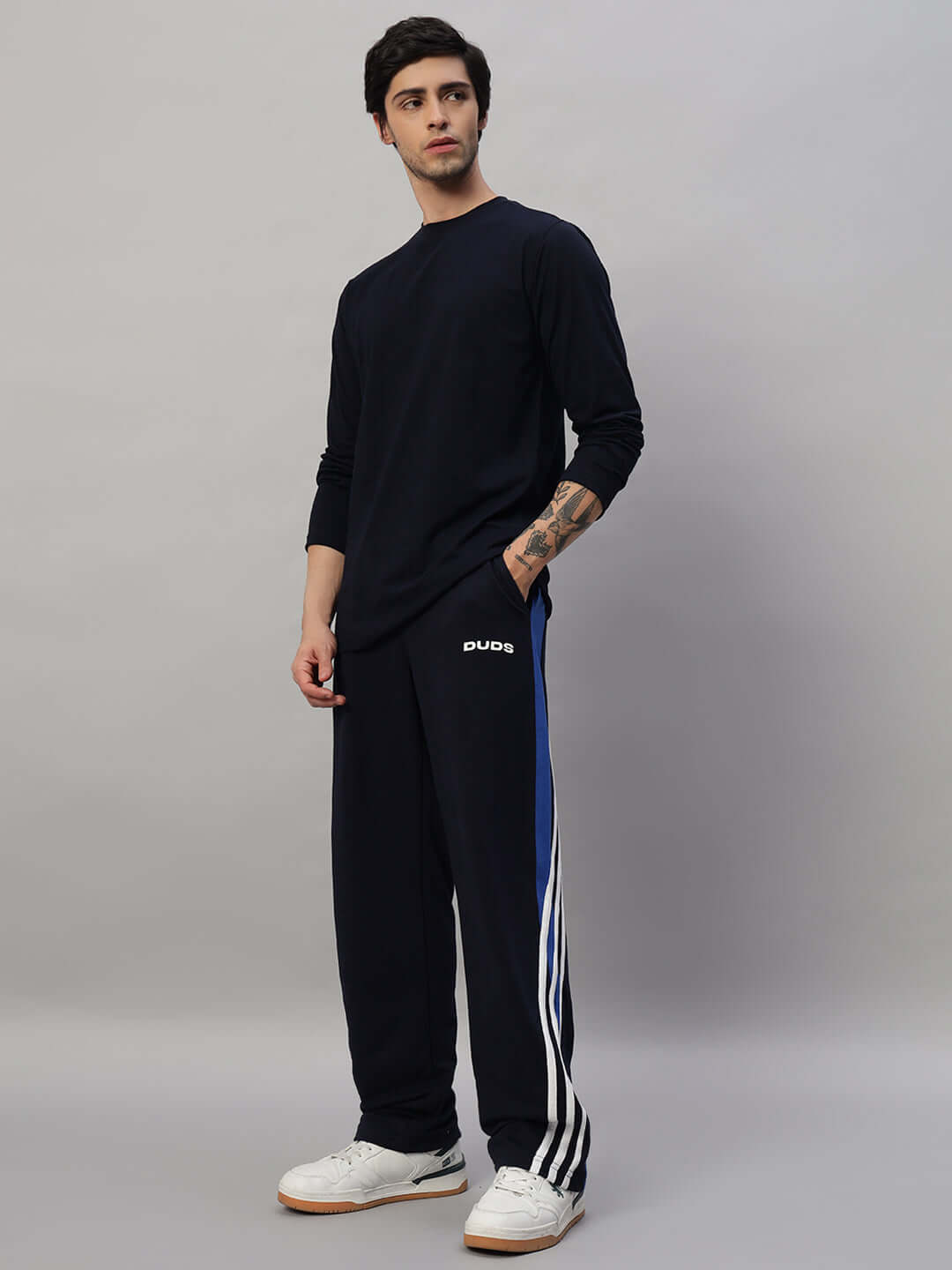 Man wearing navy blue FLIMSY SLIM FIT sweatshirt with track pants, showcasing a casual look, ideal for everyday wear.