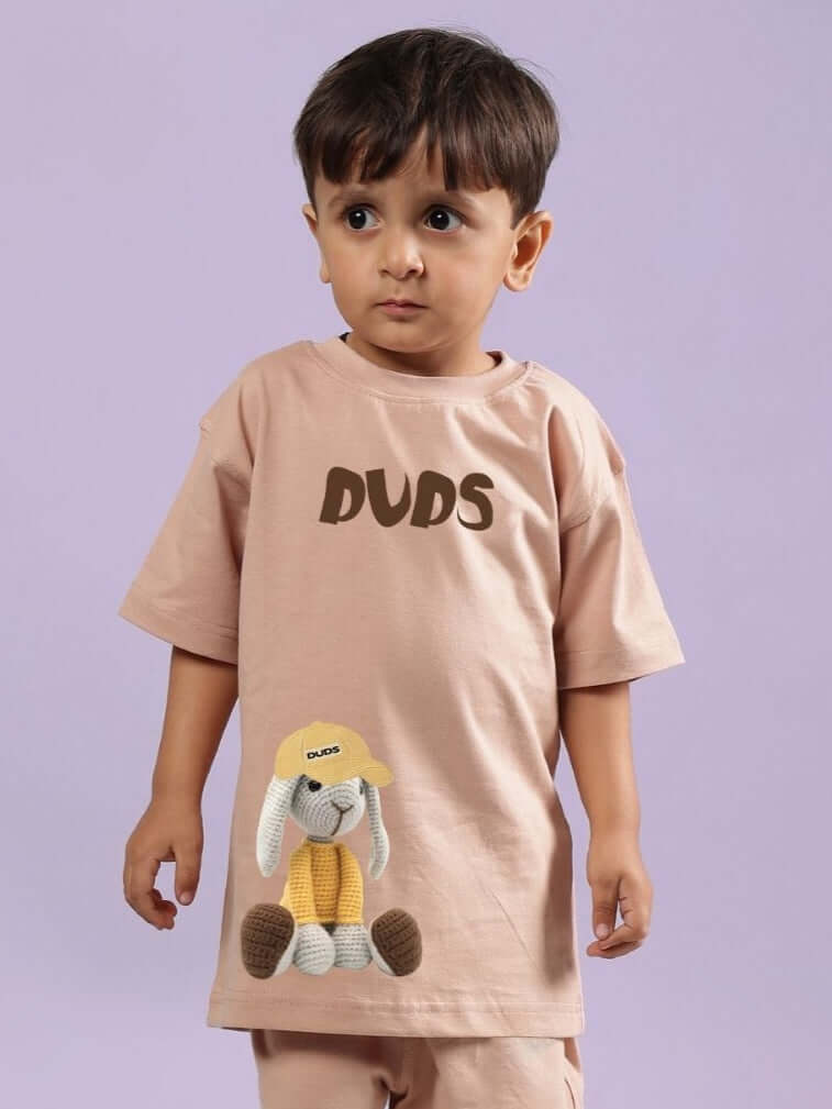 Young child wearing FLINT BUNNY T-SHIRT FOR BOYS AND GIRLS BEIGE with cute bunny graphic, perfect for playful kids fashion.
