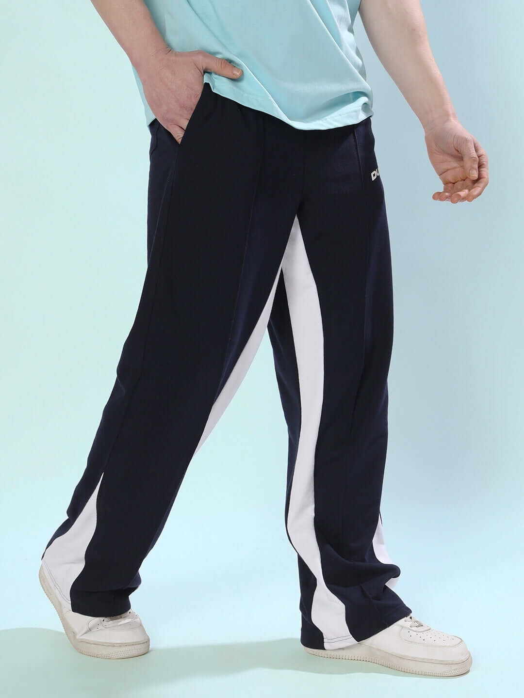 Navy blue floppy flared joggers with white contrast design, worn by model with light blue shirt, featuring customizable fit option.