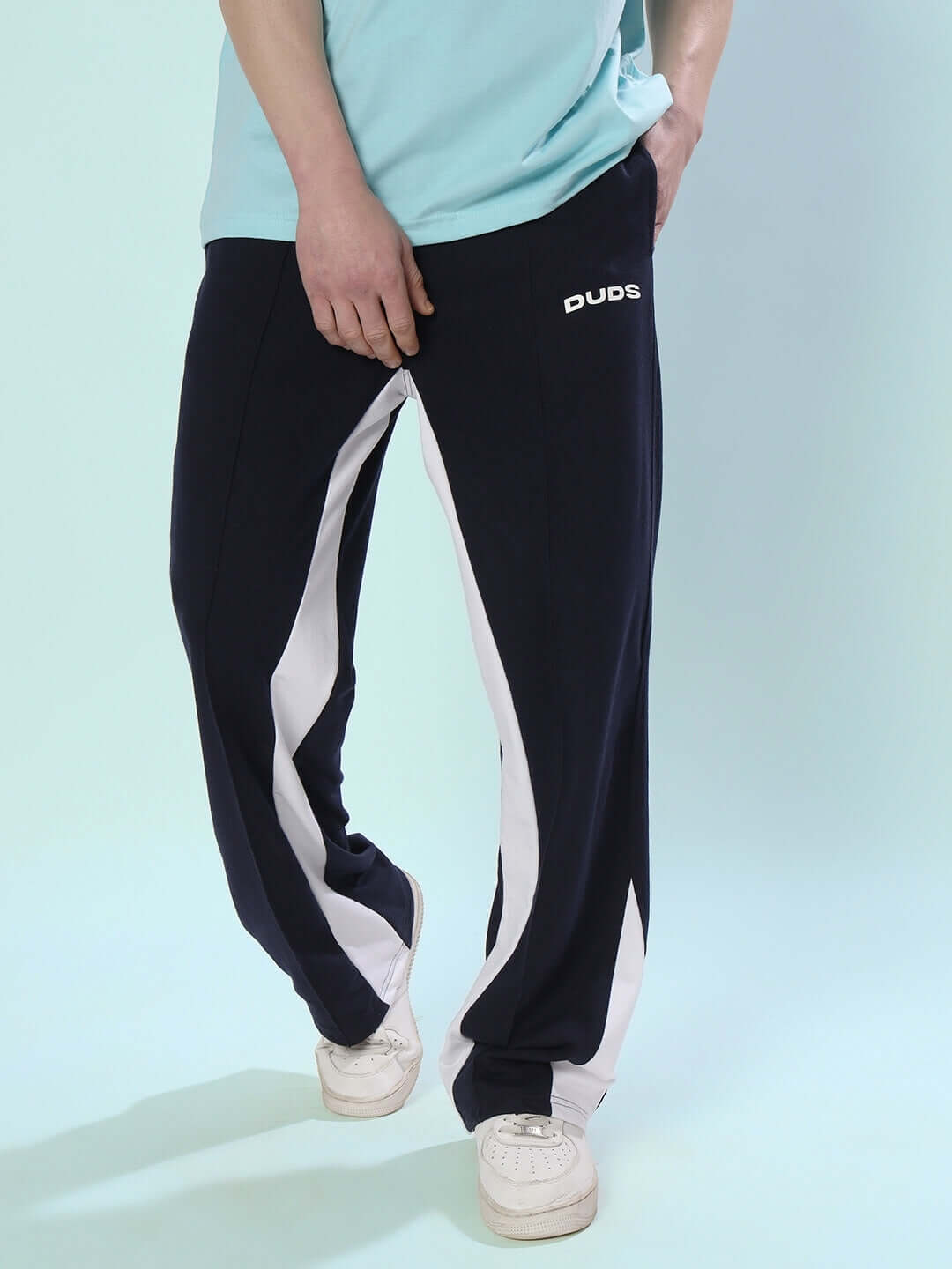 Person wearing DUDS floppy flared contrast joggers in navy blue with white stripes, styled for casual comfort.