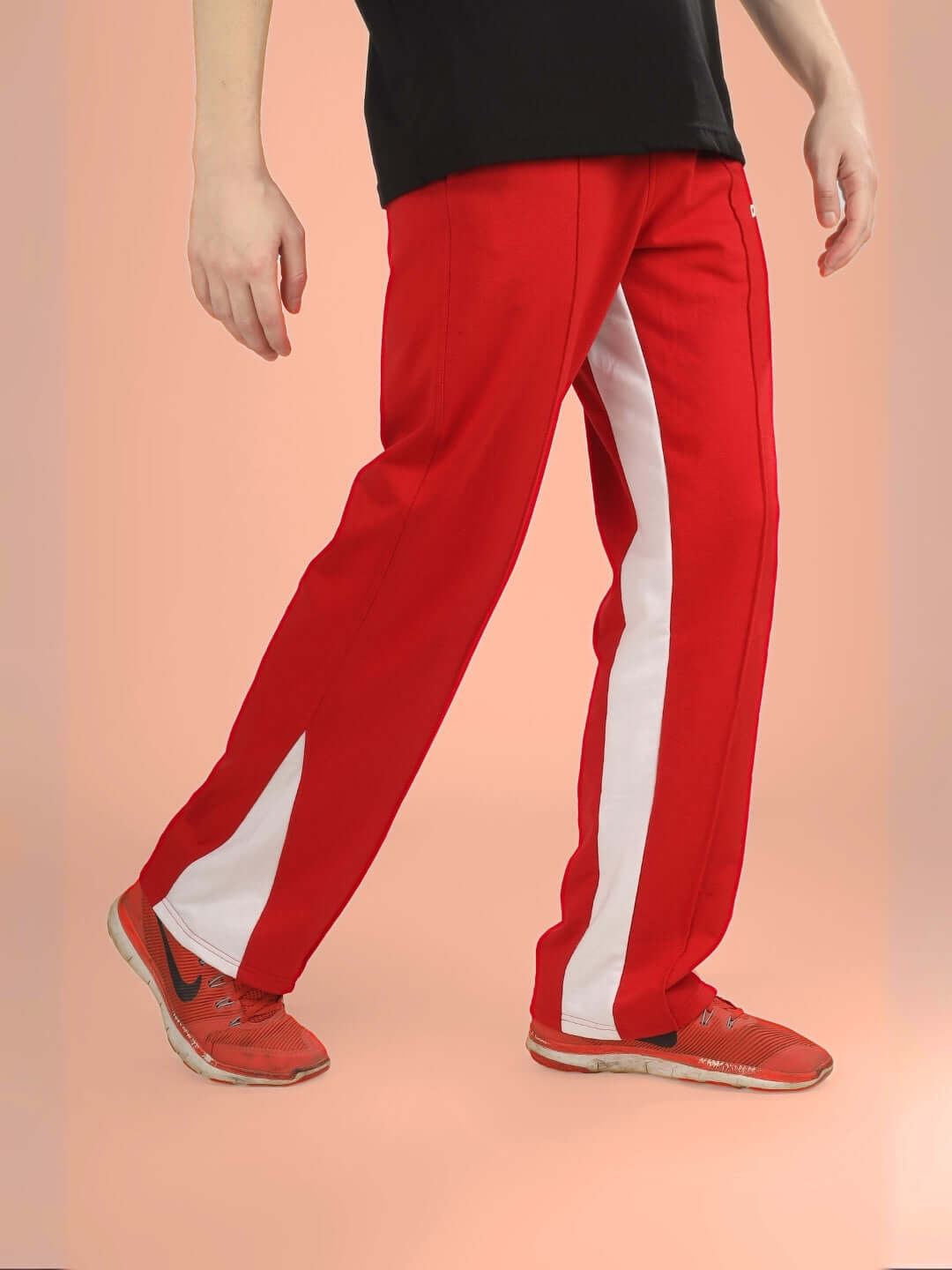 Person wearing red floppy flared contrast joggers with white stripe, highlighting customizable fit options.