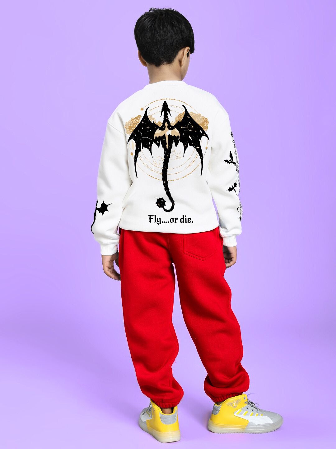 Boy wearing FLY OR DIE DRAGON FLEECE CO-ORD FOR BOYS AND GIRLS WHITE RED with dragon design, yellow sneakers on purple background