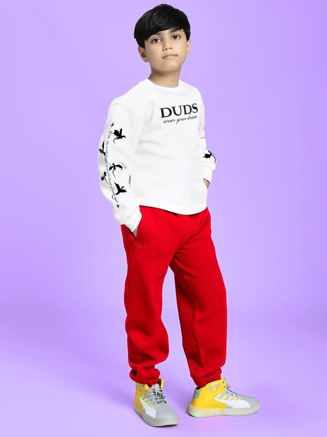 Child wearing FLY OR DIE DRAGON FLEECE CO-ORD FOR BOYS AND GIRLS WHITE RED, showcasing trendy street-style outfit on a purple background.