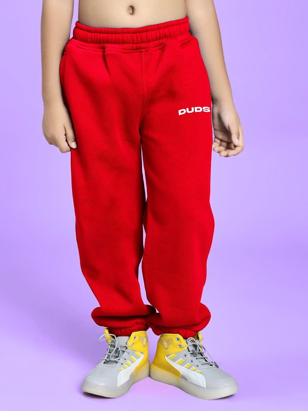Child wearing FLY OR DIE DRAGON FLEECE CO-ORD FOR BOYS AND GIRLS WHITE RED, showcasing trendy red pants with colorful sneakers.