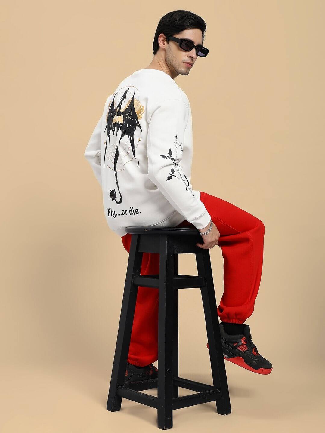 Model wearing FLY OR DIE DRAGON PRINT FLEECE CO-ORD SET OFF WHITE RED, showcasing dragon motif on back and side seam designs.