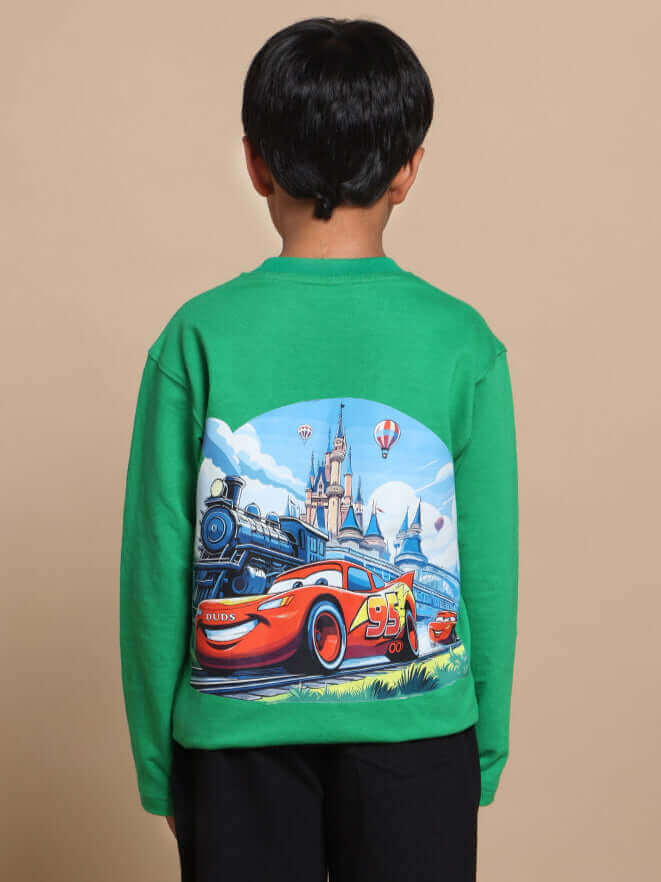 Child wearing green Formula 1 co-ord with colorful car and castle design on back.