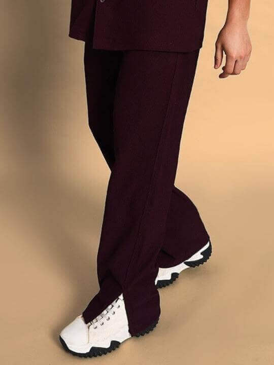Model wearing FROWZY SIDE SLIT JOGGERS in wine color, showcasing custom fit design with casual sneakers by DUDS.