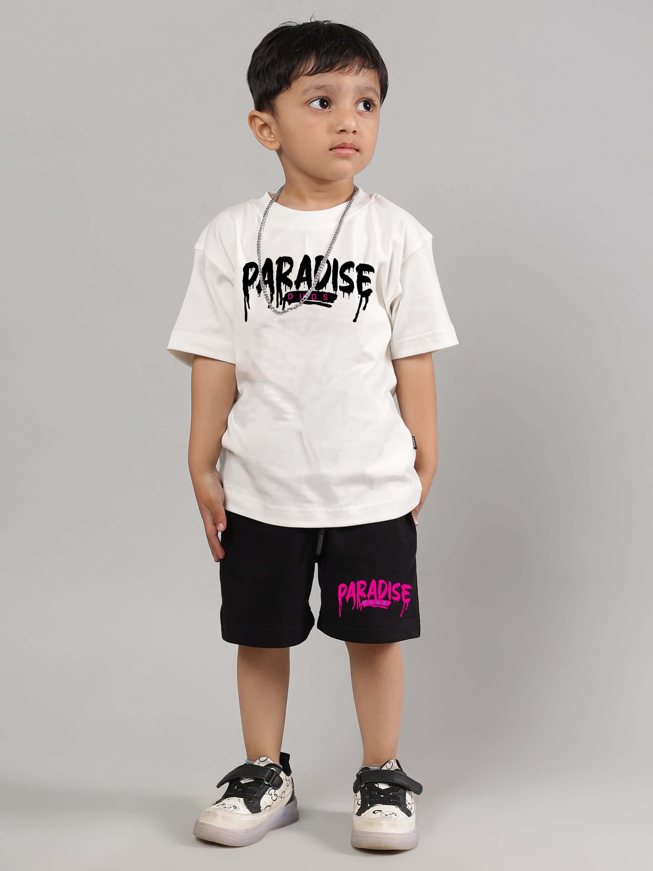 Boy wearing black summer shorts and white Paradise t-shirt
