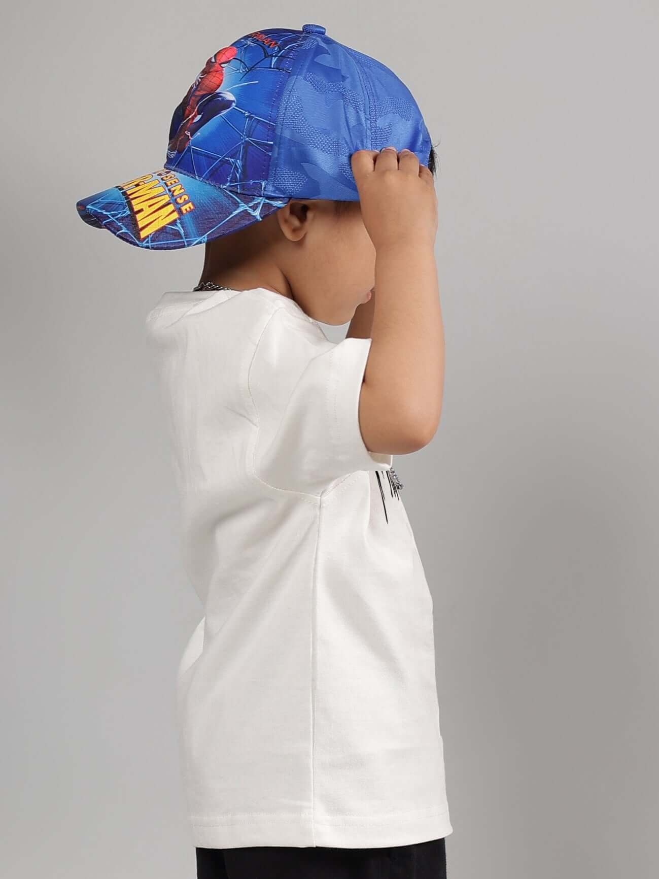 Boy wearing off-white Fulness Paradise t-shirt and blue cap, side view.