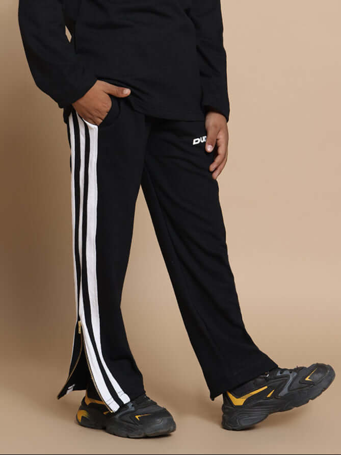 Child wearing FUN-BABE black joggers with white stripes, custom fit available, made by DUDS, suitable for boys and girls.