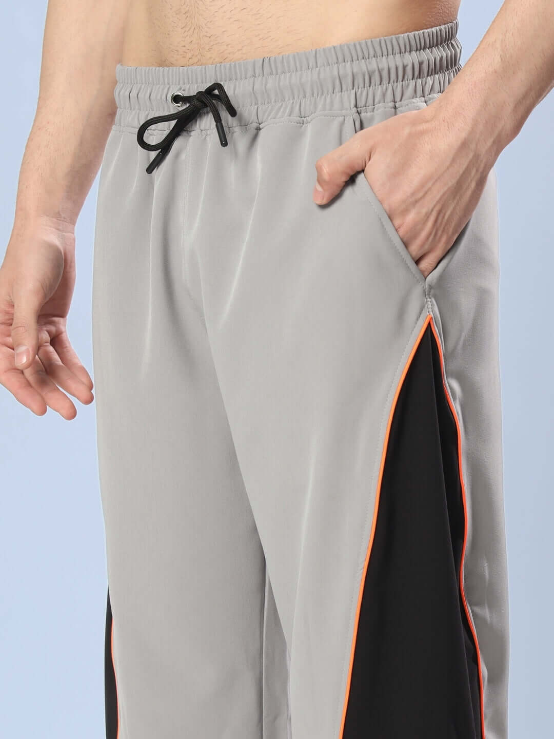 Grey relaxed fit cargo pants with side pocket and drawstring waist, featuring black and orange accents, ideal for casual wear.