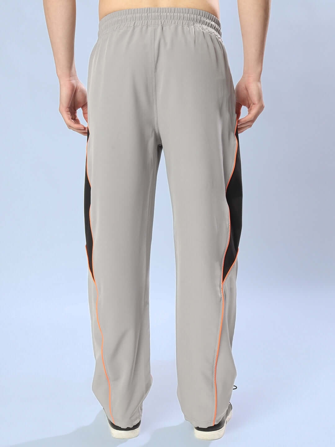 Back view of grey cargo pants with relaxed fit and black side panels.