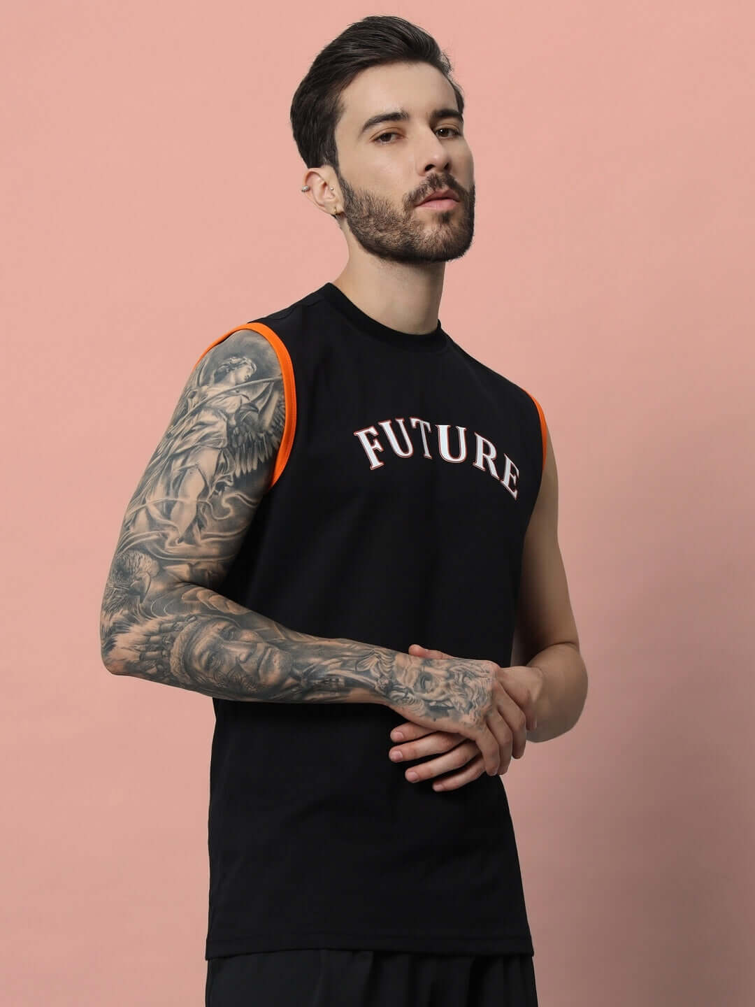 Man wearing a black FUTURE gym t-shirt, showcasing sleek design with orange highlights on sleeves, perfect for workouts and custom fit options.