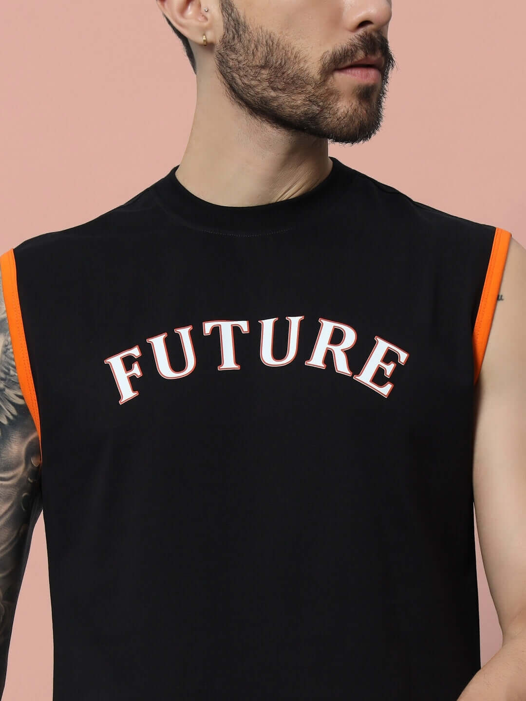 Man wearing a black FUTURE gym t-shirt with orange trim, emphasizing custom fit option for personalized sizing.