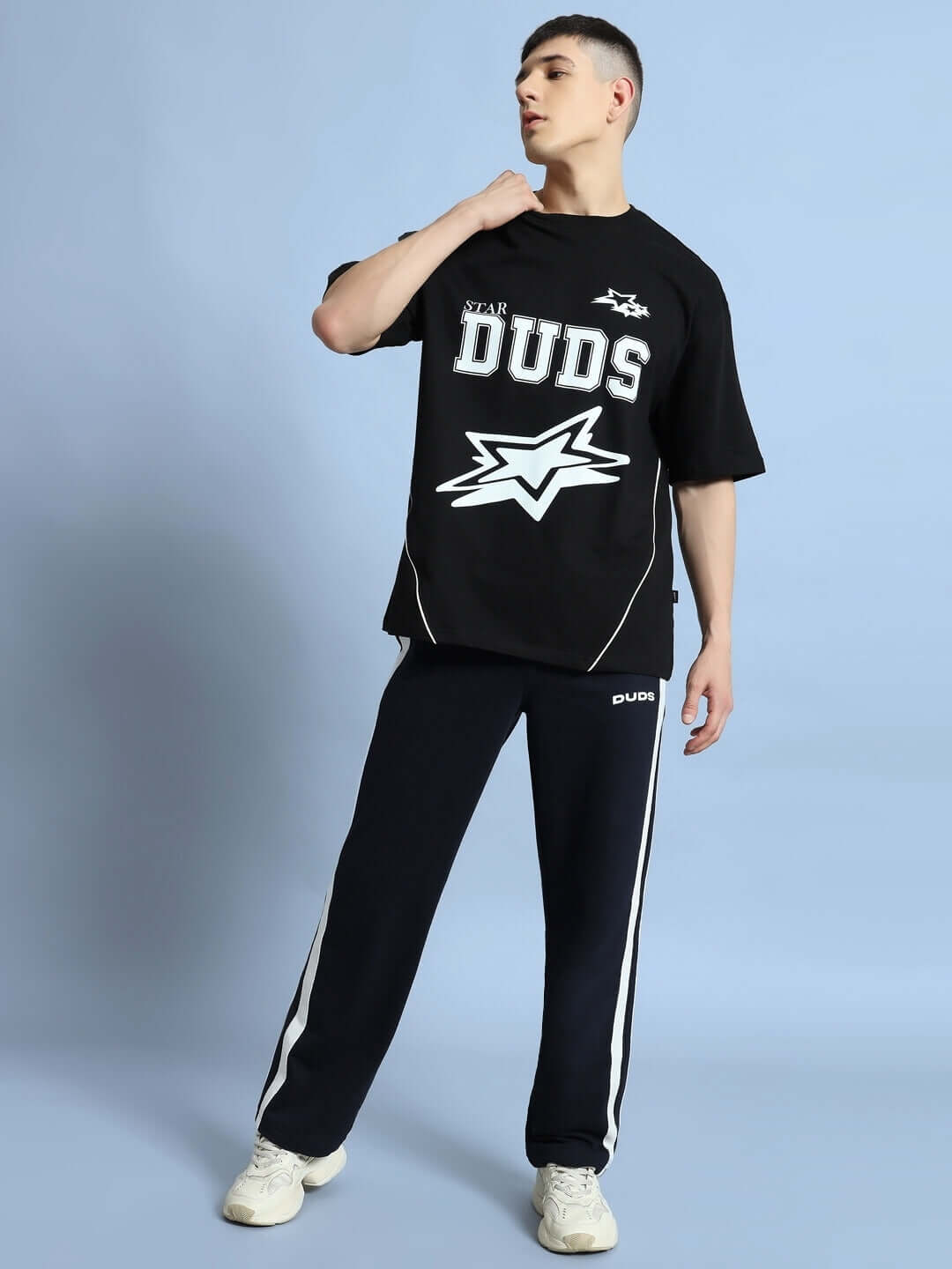 Model wearing black GALAXY OVER-SIZED T-SHIRT by DUDS, featuring bold graphics, paired with sporty black pants.