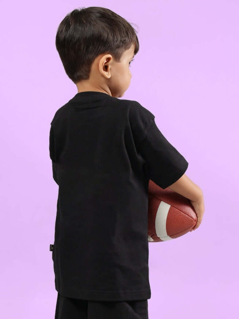 Child holding a football wearing GAME FINISHER T-SHIRT FOR BOYS & GIRLS BLACK.