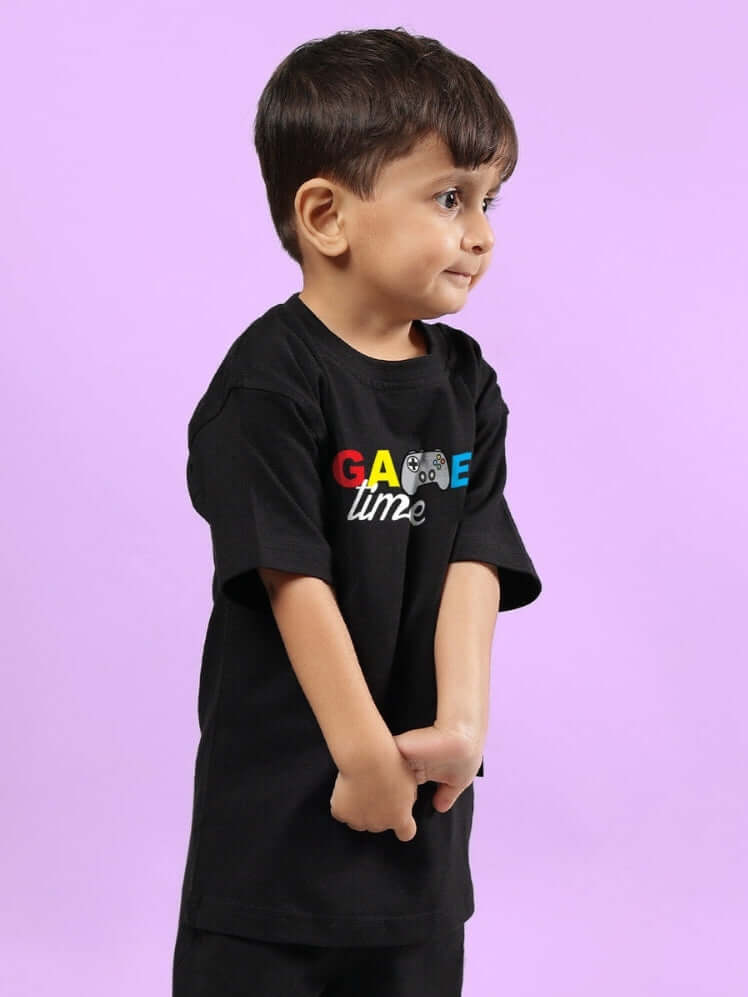 Young child wearing GAME FINISHER T-SHIRT FOR BOYS & GIRLS BLACK standing against a purple background.