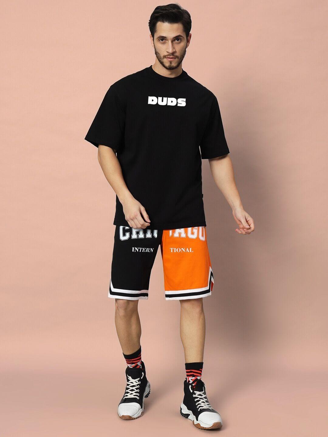 Model wearing GAME-OVER OVER-SIZED T-SHIRT BLACK with graphic shorts