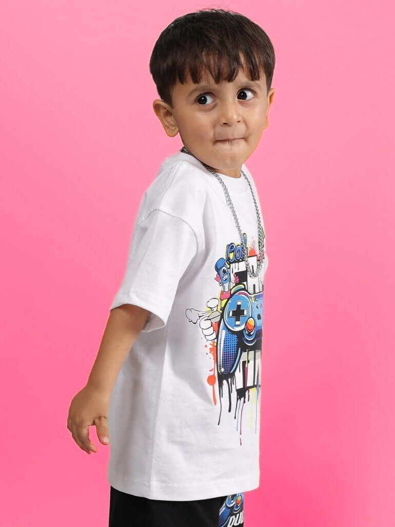 GAME TIME T-SHIRT FOR BOYS GIRLS WHITE with colorful graphic worn by young child against pink background.