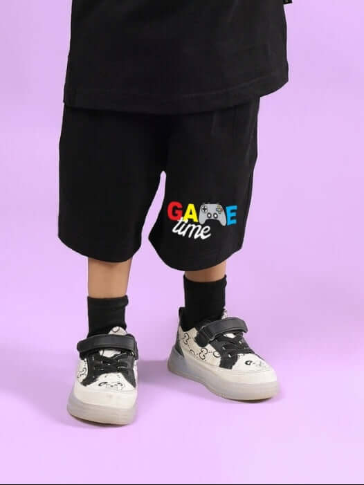 GAME FINISHER SHORTS FOR BOYS & GIRLS BLACK with colorful 'Game' embroidery on left side against a purple background.