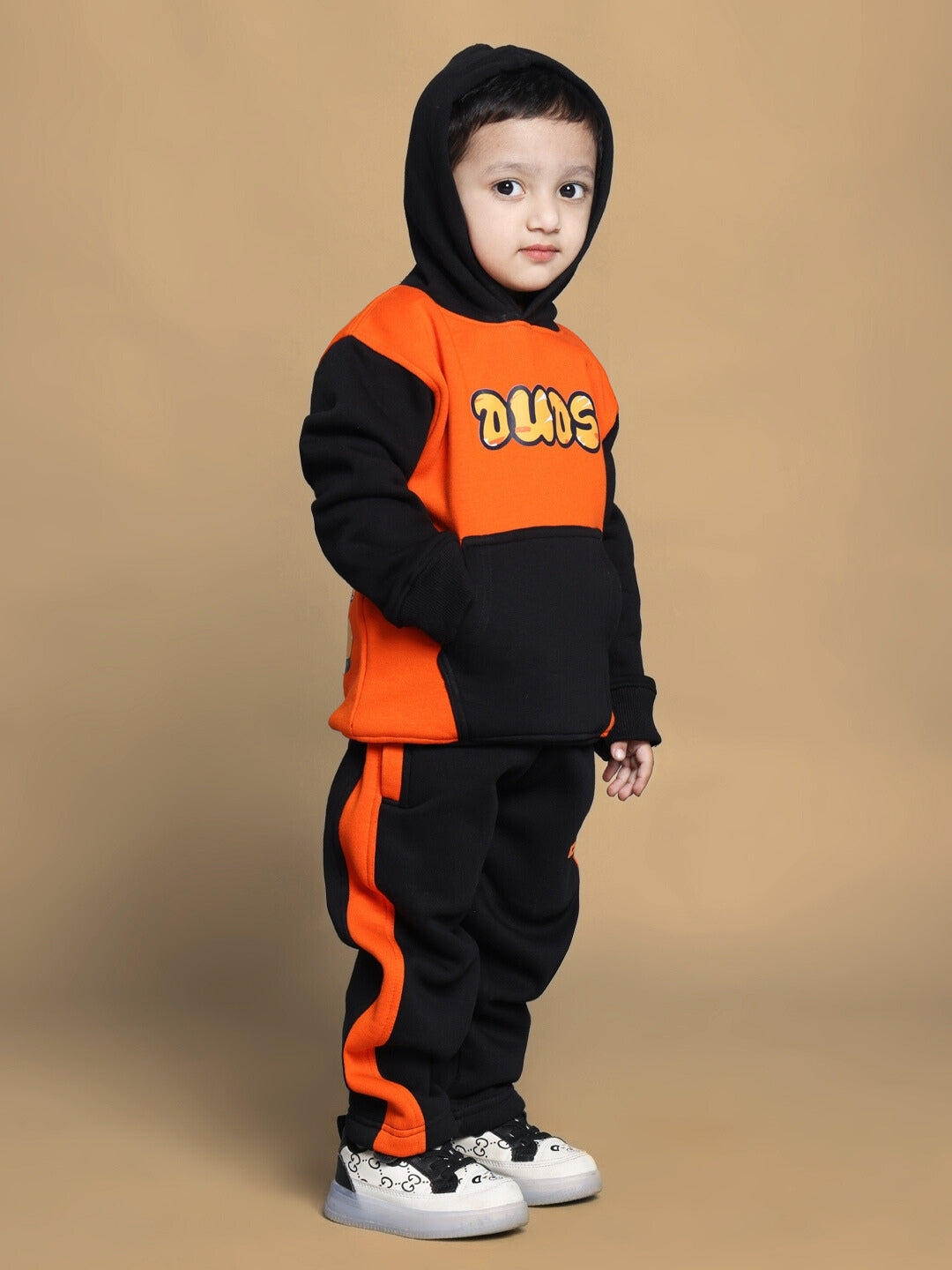 Child wearing COOL TEDDY FLEECE PANT FOR BOYS GIRLS BLACK ORANGE, showcasing bold color and playful design, ideal for outdoor activities.
