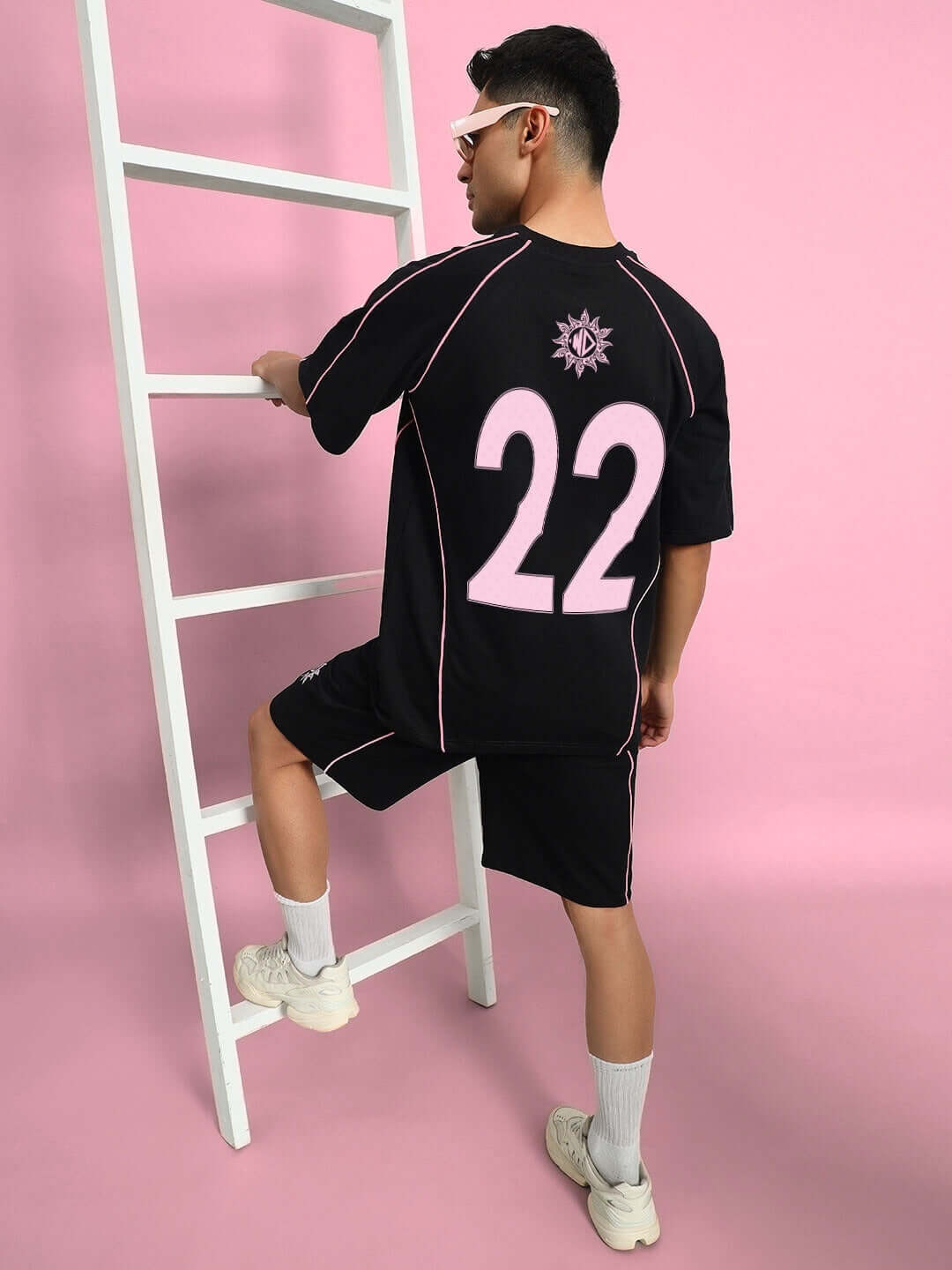 Model wearing GLARE COTTON TERRY CO-ORD SET BLACK with sporty design and pink accents, perfect for casual outings.