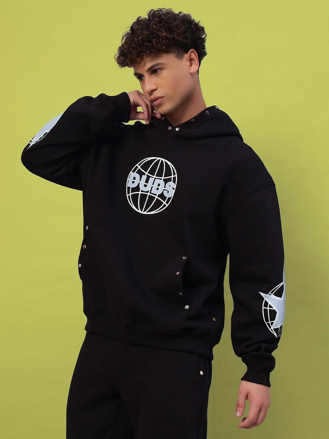 Model wearing GLOBAL COTTON FLEECE HOODIE BLACK, showcasing streetwear style.