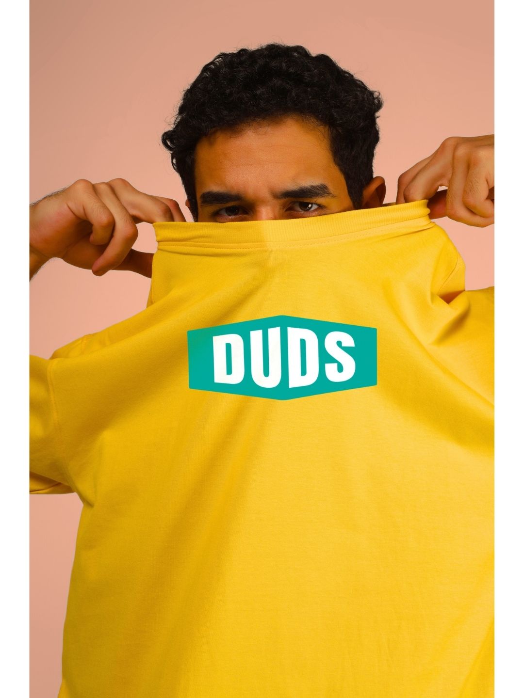Man wearing GO WILD ADVENTURE OVER-SIZED T-SHIRT YELLOW with "DUDS" logo displayed.