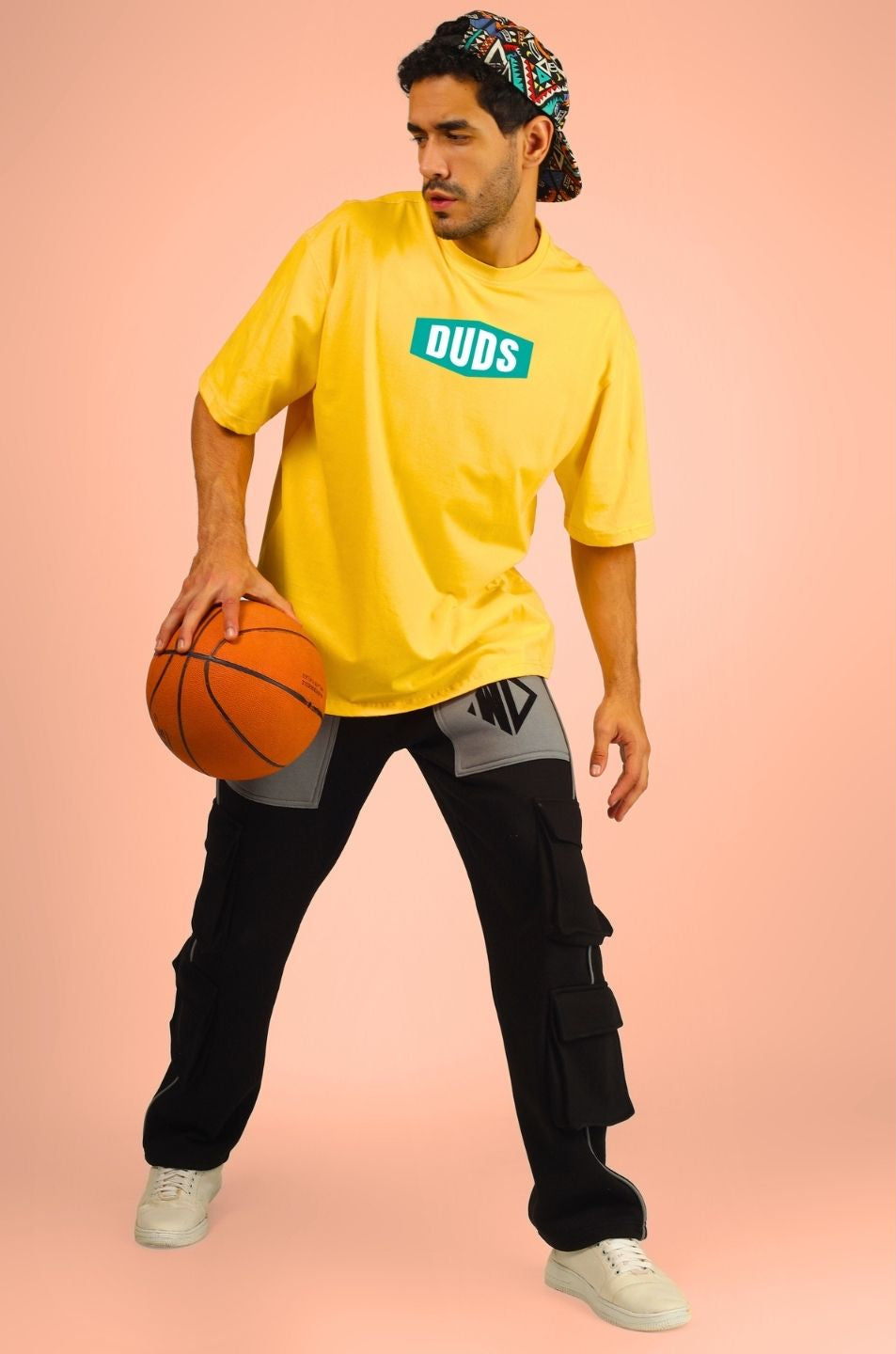 Man wearing GO WILD ADVENTURE OVER-SIZED T-SHIRT YELLOW holding a basketball