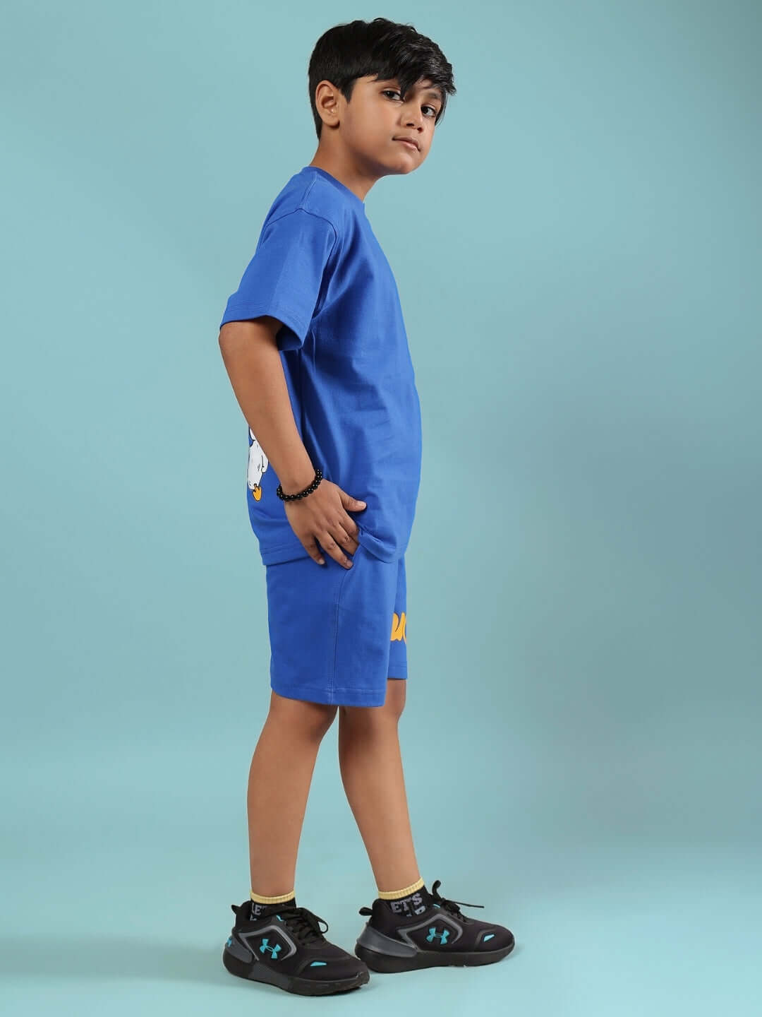 Child wearing blue GO MOTION co-ord; a stylish, made-to-order set for boys and girls, available in customizable sizes from DUDS.