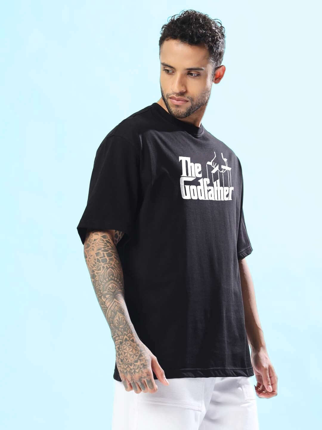 Man wearing a black oversized "Godfather" t-shirt, showcasing a casual yet stylish look.