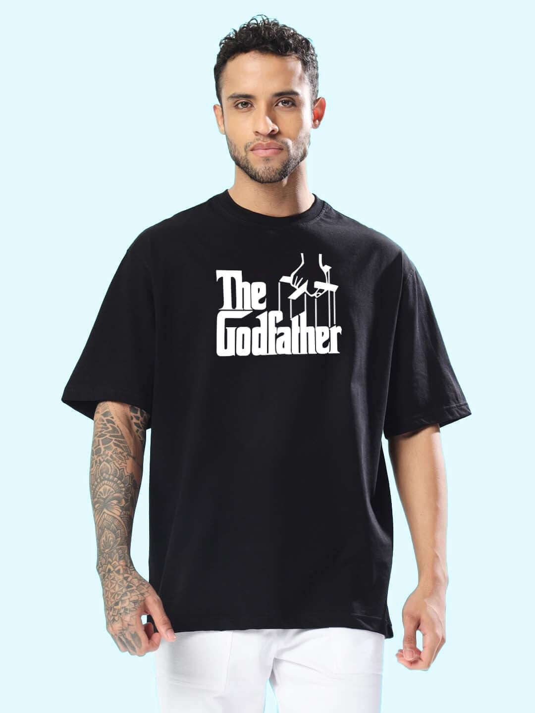 Man in an oversized black t-shirt featuring 'The Godfather' logo, ideal for custom fit options and handmade quality by DUDS.