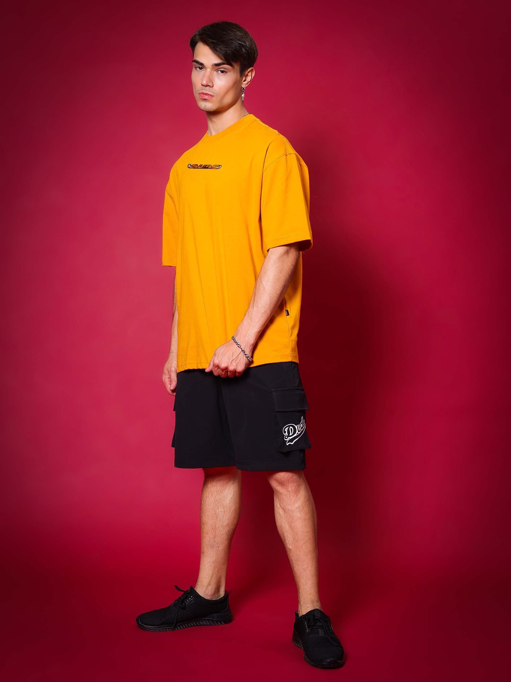 Model wearing GOHAN oversized mustard T-shirt by DUDS; custom fit option available for prepaid orders, handmade with dedication.