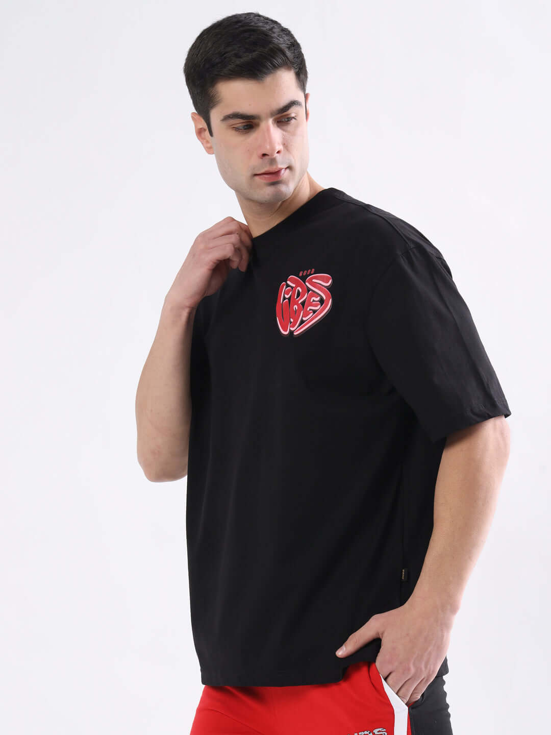 Man wearing GOOD VIBES oversized black t-shirt with custom fit option available, highlighting comfort and style for every occasion.