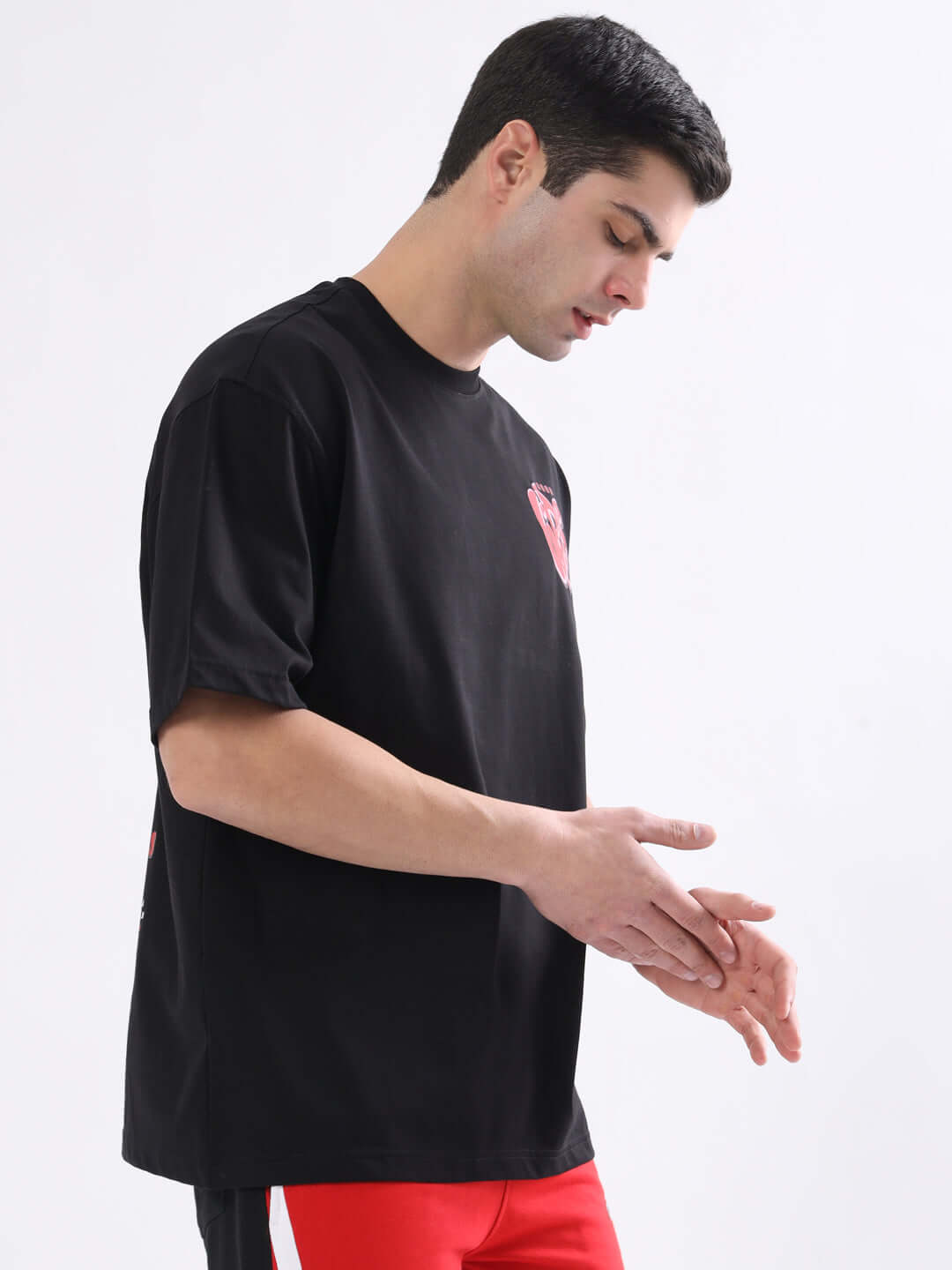 Man wearing a black oversized t-shirt with 'Good Vibes' print, available with custom fit option, crafted by DUDS.