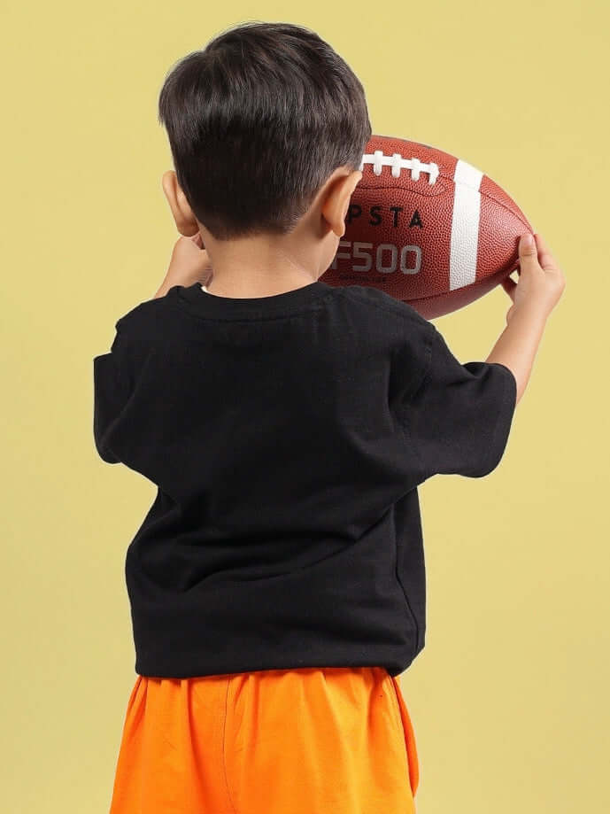 Child holding a football wearing Goofy Oversized T-Shirt for Boys Girls Black