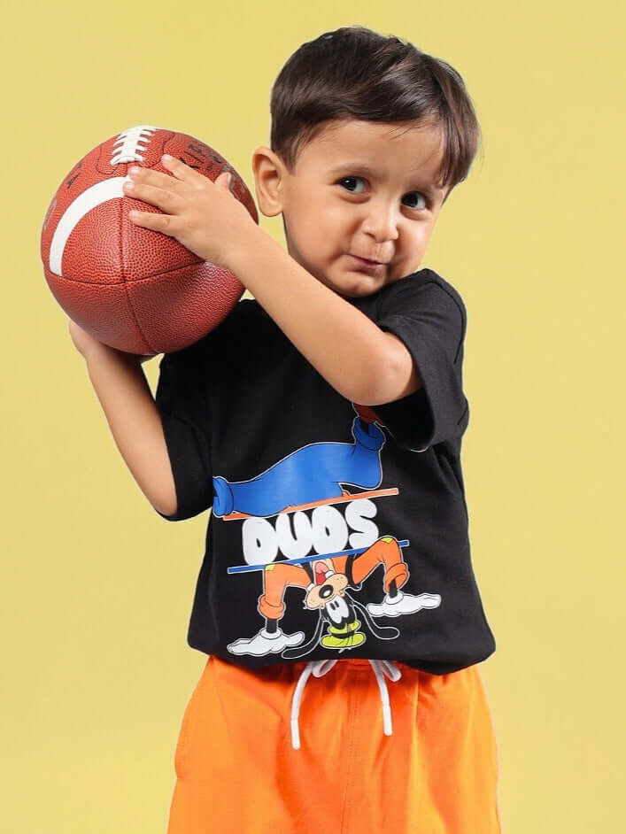 Child wearing Goofy Oversized T-Shirt for boys girls black and holding a football