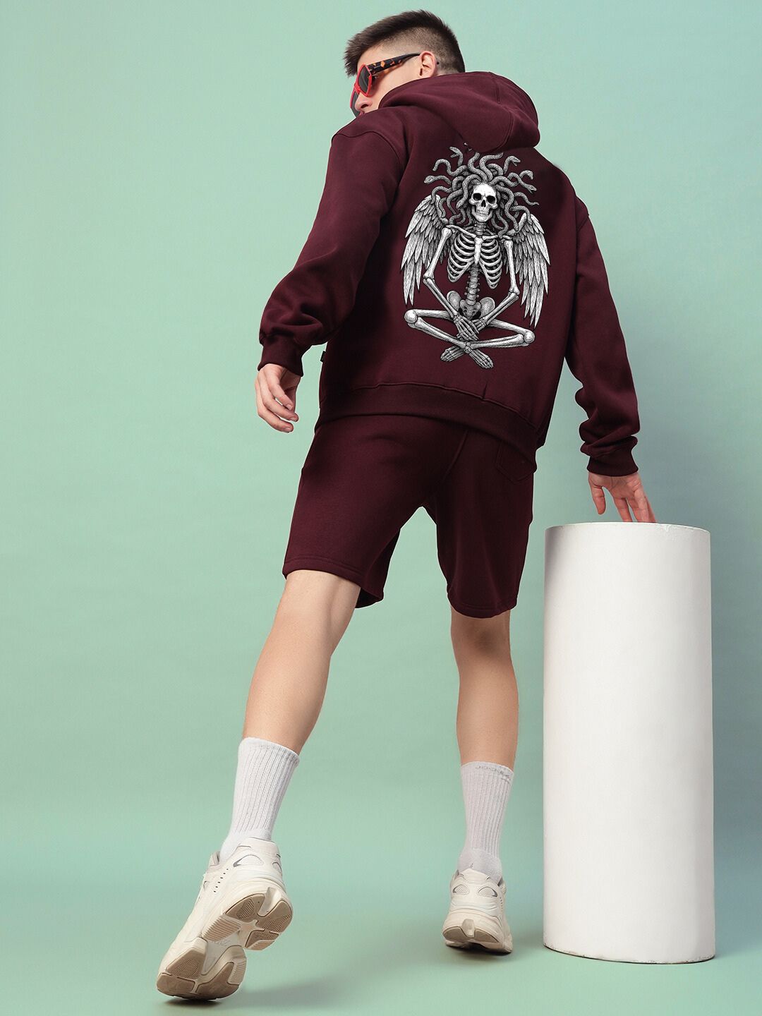 Man wearing GORGON SKULL PRINTED FLEECE CO-ORD SET WINE with striking skull graphic, showcasing trendy streetwear fashion.