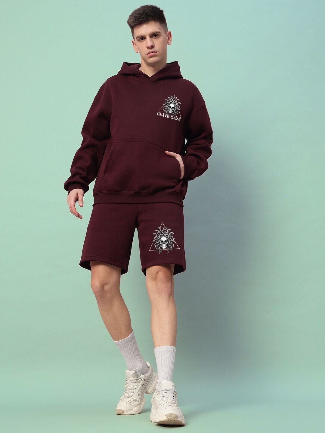 Model wearing GORGON SKULL PRINTED FLEECE CO-ORD SET WINE in maroon with striking skull graphics, showcasing streetwear fashion.