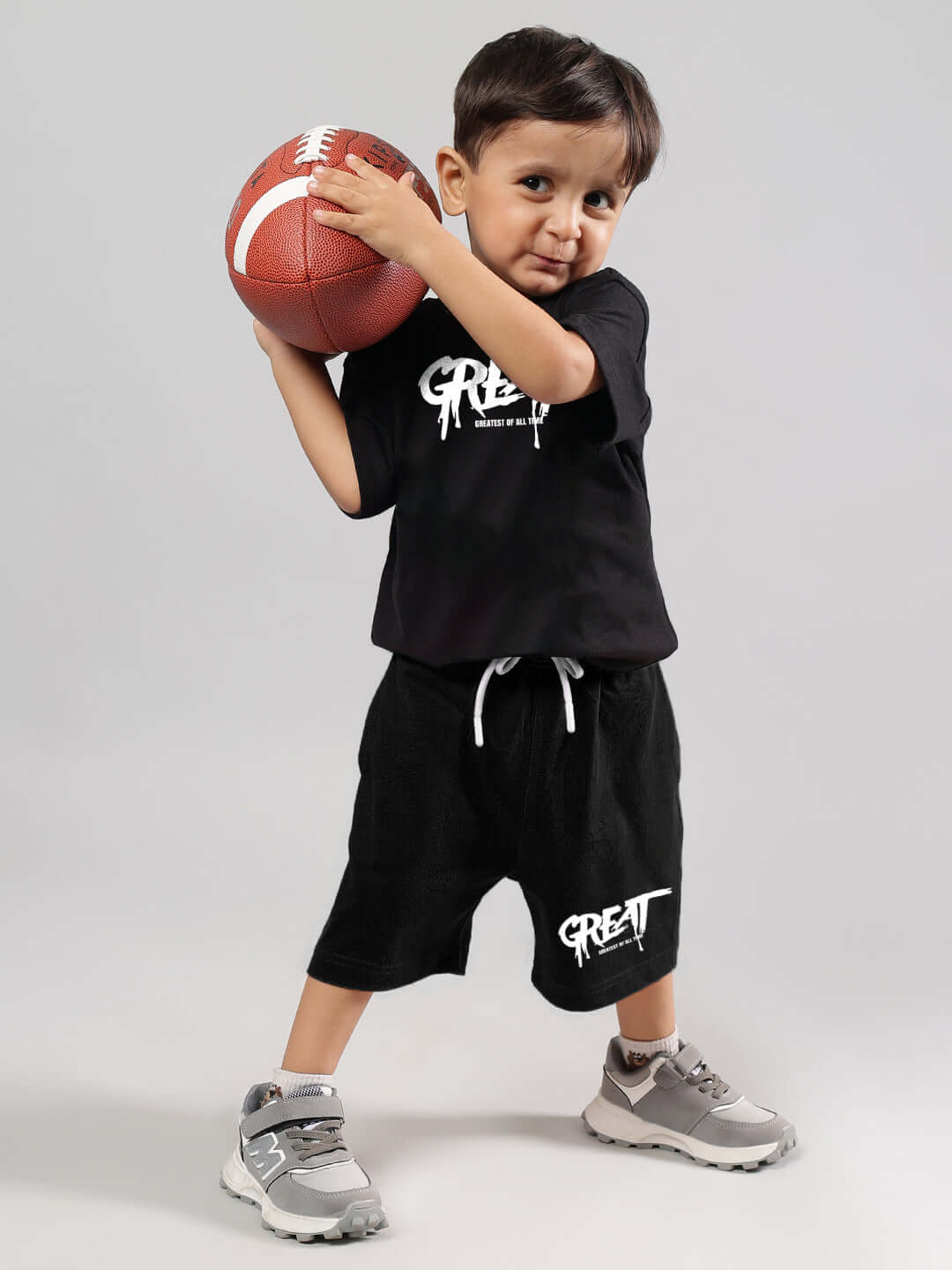 Child in GREAT PRINTED SUMMER CO-ORD FOR BOYS GIRLS BLACK holding a football, showcasing comfortable and stylish kids' outfit.